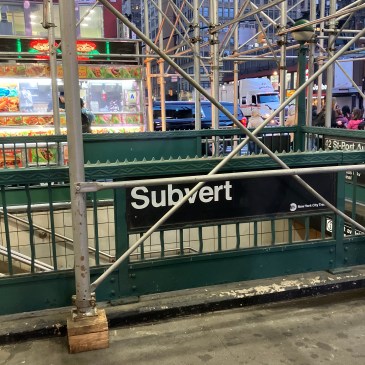 steps down to the subway at 42 st in nyc. someone has changed the sign to read subvert